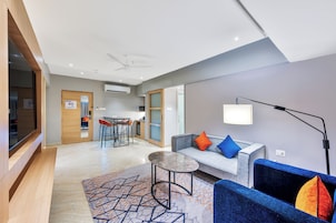 Eine moderne Hotellobby mit einer Sitzecke, einem kleinen Tisch und einer Couch mit Kissen.
