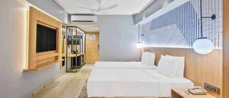 A modern hotel room with a large bed, bedside tables, a TV, and a ceiling fan.