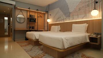 A modern hotel room with a large bed, bedside tables, a mirror, and a wall-mounted TV.