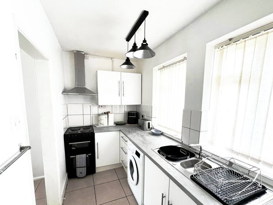 Cocina compacta con lavadora, estufa y lavaplatos.
