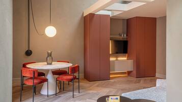 Un área de comedor moderna con una mesa redonda, sillas rojas y una lámpara colgante.