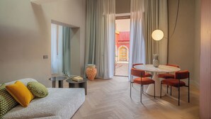 A modern hotel room with a sofa, a dining table with chairs, a vase, and a large window with curtains. - Villa Conrad by Hotel Metropole Taormina (Taormina)