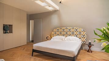 Una camera da letto moderna con un letto, un comodino con una lampada e una mensola a parete.