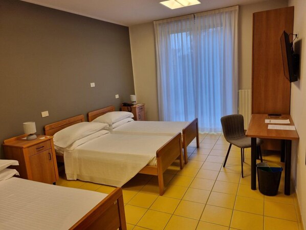A hotel room with two beds, a desk, a chair, and a television. - Phi Hotel Homy Druento (Druento)
