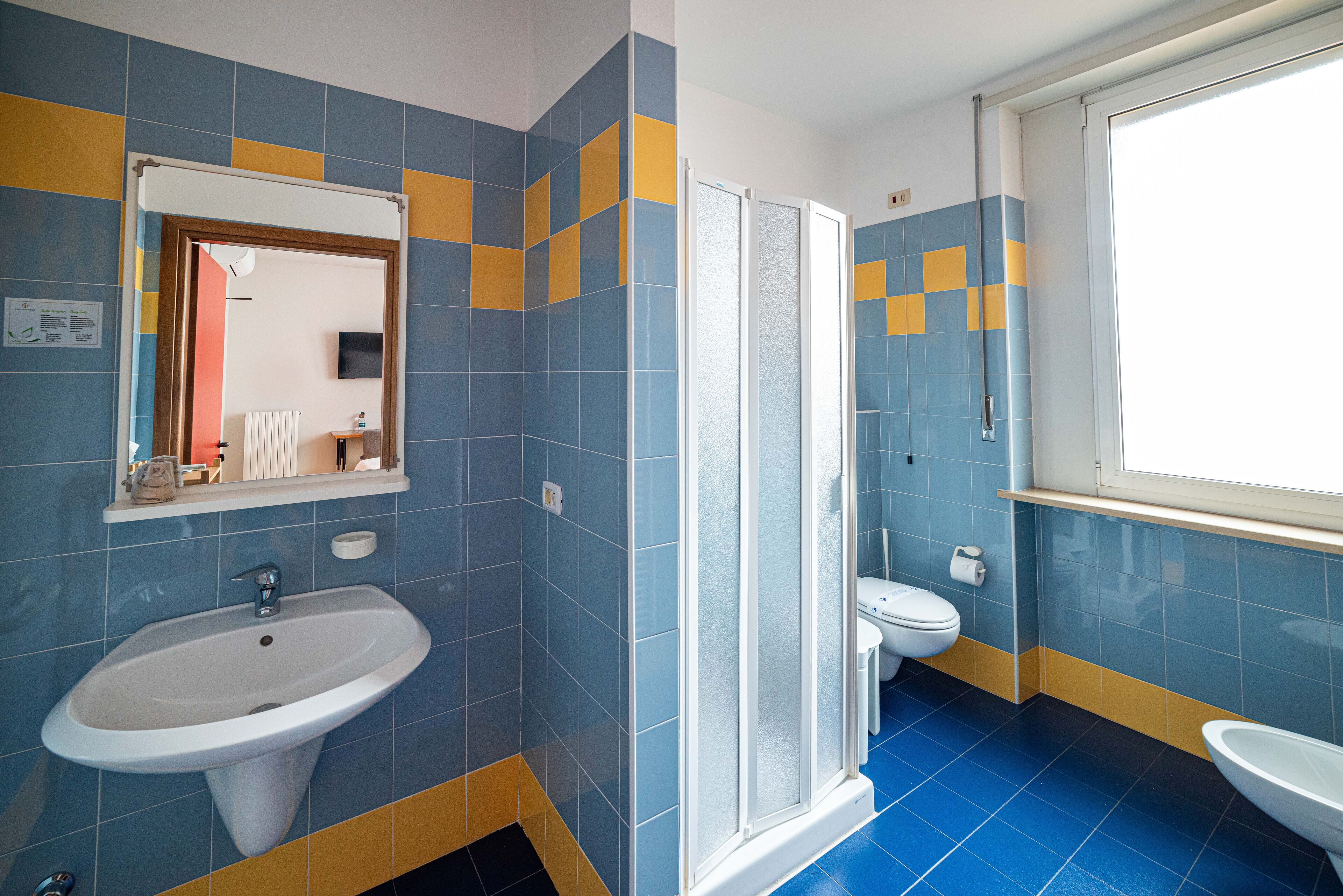 A bathroom with a sink, toilet, and shower.