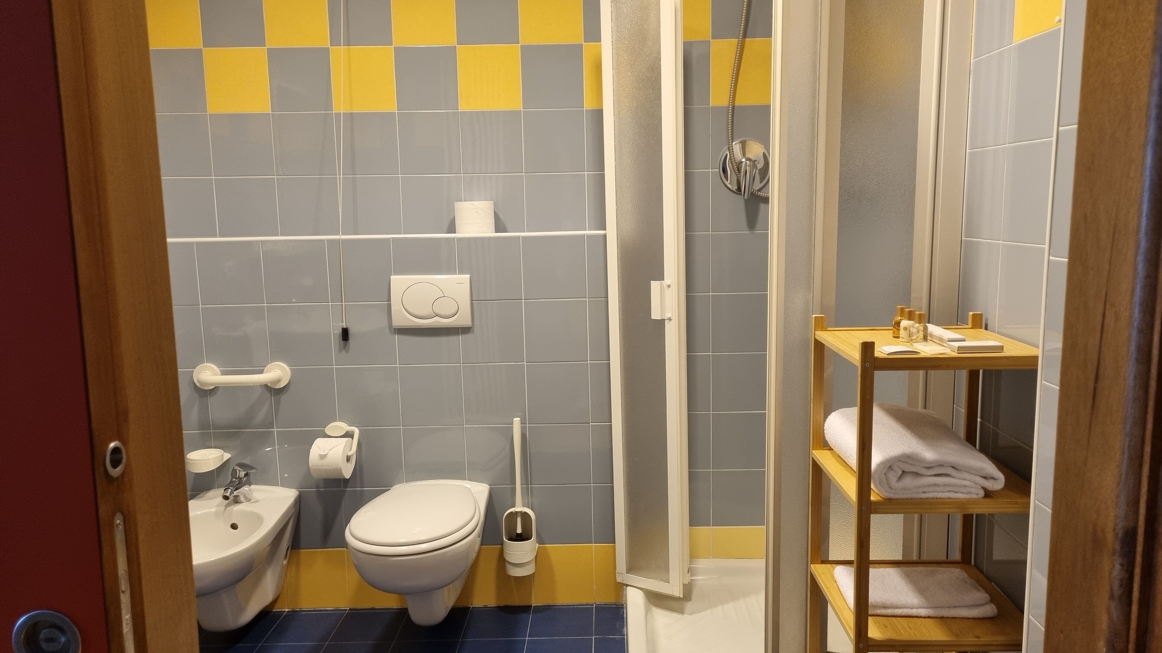 A bathroom with a bidet, toilet, and a shower stall.