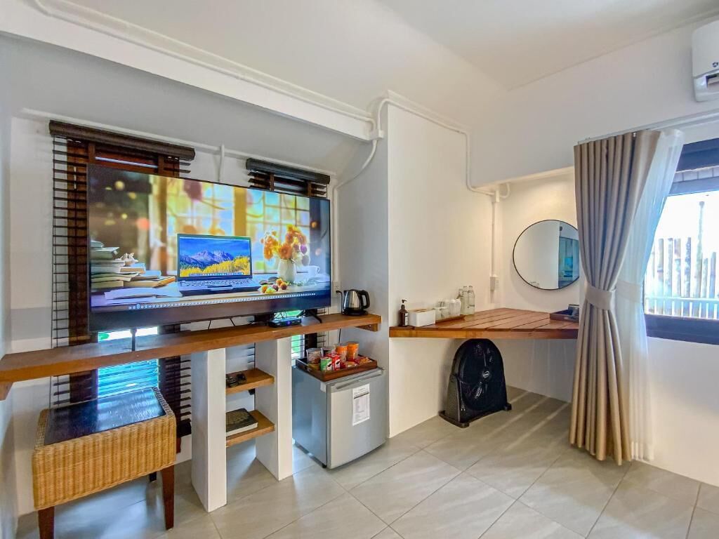 A compact living space with a TV, kitchenette, and a small seating area.