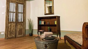 A room with a wooden floor, a vintage-style bed, a bookshelf, a mirror, and a large window with curtains. - CASCINA D'OLTRALPE - MONGINVERO - FAMILY APARTMENT (Susa)