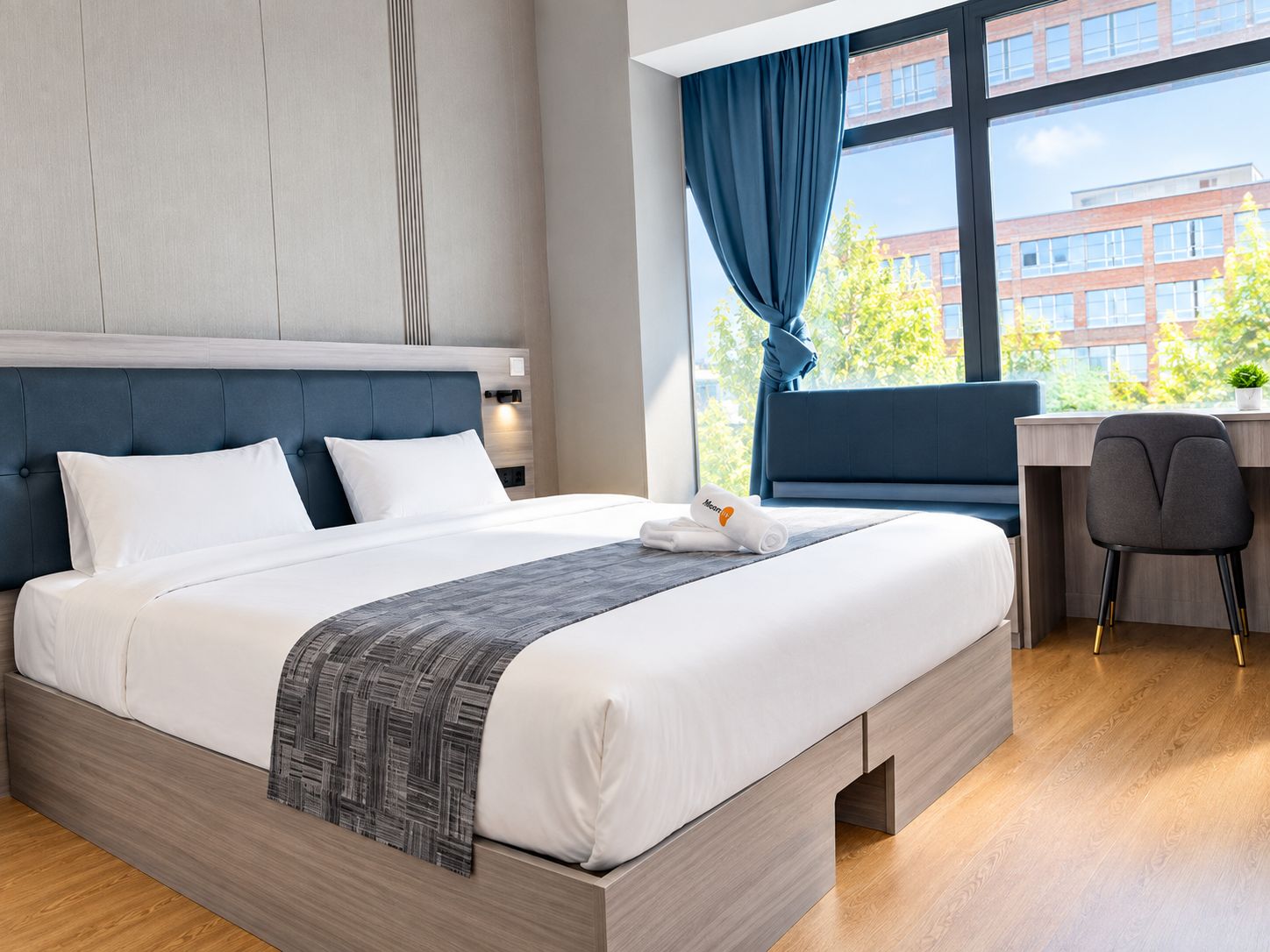 Ein modernes Hotelzimmer mit einem großen Bett, einem Schreibtisch und Blick auf Gebäude.