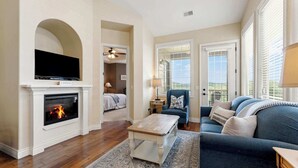 A living room with a fireplace, a sofa, a coffee table, and a television.