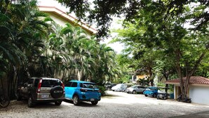 Una calle residencial con coches aparcados y árboles.
