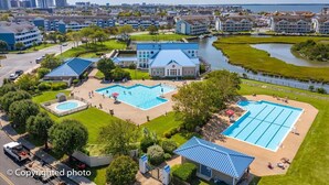 Un hôtel doté de plusieurs piscines, un grand bâtiment avec un toit bleu et une vue sur le panorama urbain.