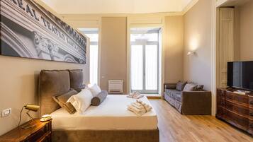 Una camera da letto con un letto grande, una televisione, un comò e un quadro appeso al muro.