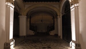 An arched corridor with a hanging lantern, stone floor, and white walls. - Divisi Suites & SPA (Palermo)