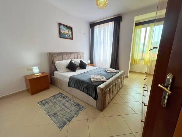 Un dormitorio con cama, mesita de noche y alfombra.