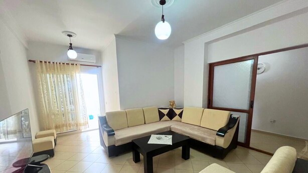 A living room with a sectional sofa, a coffee table, and a TV.