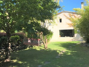 A building with a stone wall, a hammock, and a grassy yard. - Casa-Amanda pinede piscine privée calme absolu (Mimet)