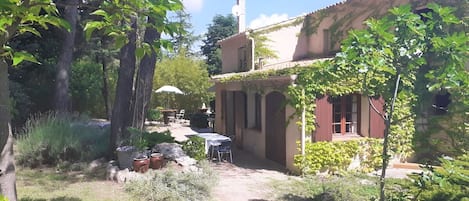 A courtyard with a building, outdoor seating, and greenery.