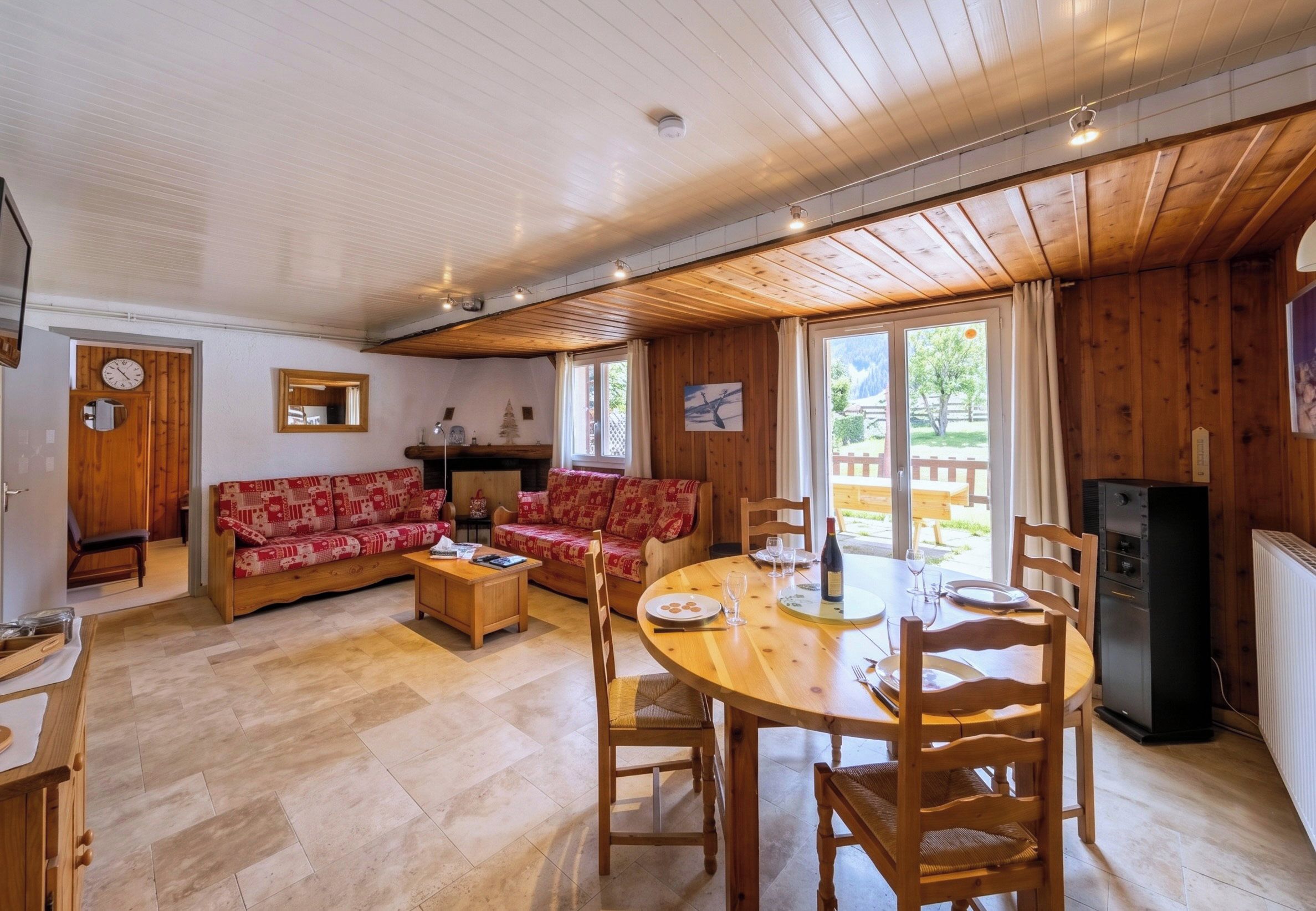 Un salon confortable avec un canapé, une table à manger et des chaises, ainsi qu’un coin cuisine équipé d’un réfrigérateur.
