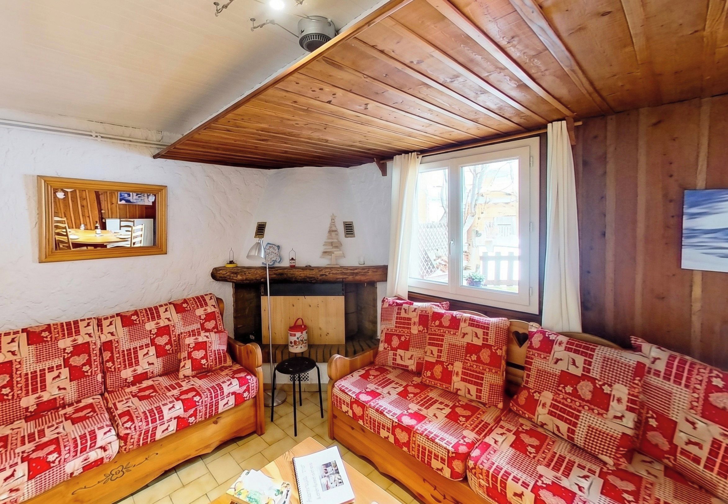 Una habitación acogedora con dos sofás de madera, una mesita y una chimenea.