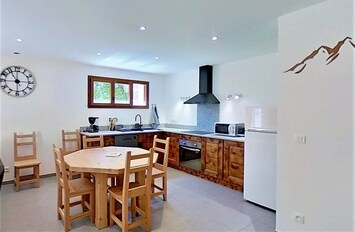 The spacious, fully equipped kitchen features a large dining table with seating for six guests, making it perfect for enjoying meals together. The kitchen is complete with modern appliances including a dishwasher, oven, and microwave, ensuring all your cu