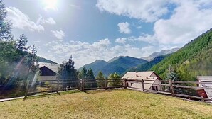 A rural landscape with a fenced area, a wooden cabin, and mountains in the background. - CASA-Joubarbe Super 4p terrasse plein sud Arvieux! (Arvieux)