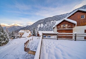 A wooden chalet with a balcony, surrounded by snow-covered trees and mountains in the background. - CASA-Joubarbe Super 4p terrasse plein sud Arvieux! (Arvieux)