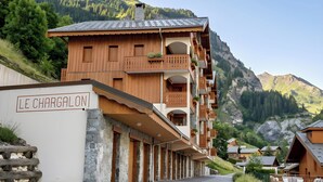 Un bâtiment en bois doté de balcons et d’une enseigne indiquant « LE CHARGALON ».