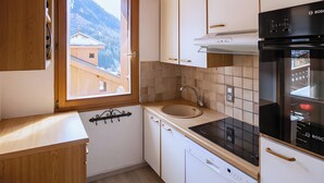 Eine Küche mit Fenster, Holdekor und Spüle, sowie ein Backofen von Bosch.
