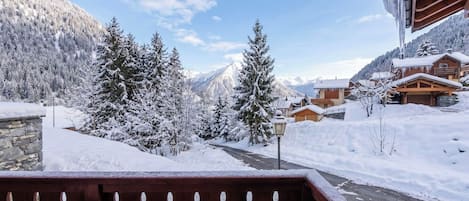 A snowy mountain landscape with wooden buildings and a clear sky.
