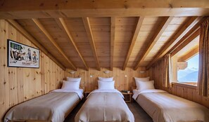 A wooden cabin room with two beds, a poster on the wall, and a window with a mountain view. - CASA-Chalet du Merle 2 à Champagny-en-Vanoise (Champagny-en-Vanoise)