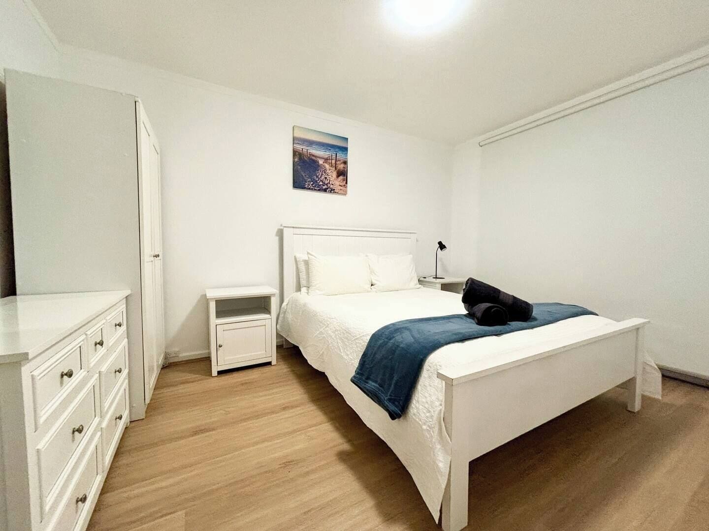 Queen bed master bedroom with ample dresser and wardrobe