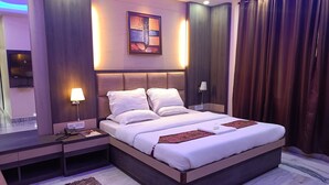 Una habitación de hotel moderna con una cama grande, lámparas de noche, un televisor de pantalla plana y piso de mármol.