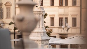 Una statua su un piedistallo di fronte a un edificio con numerose finestre e un'insegna con la scritta 'Credit'.