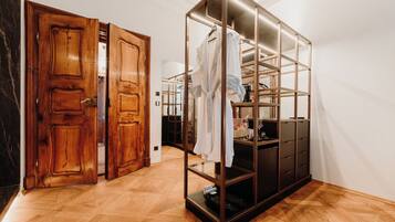 A room with a wooden door, a glass-fronted wardrobe, and a herringbone-patterned floor.