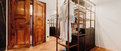 Une pièce avec une porte en bois, une armoire à façade en verre et un parquet à motifs en chevrons.