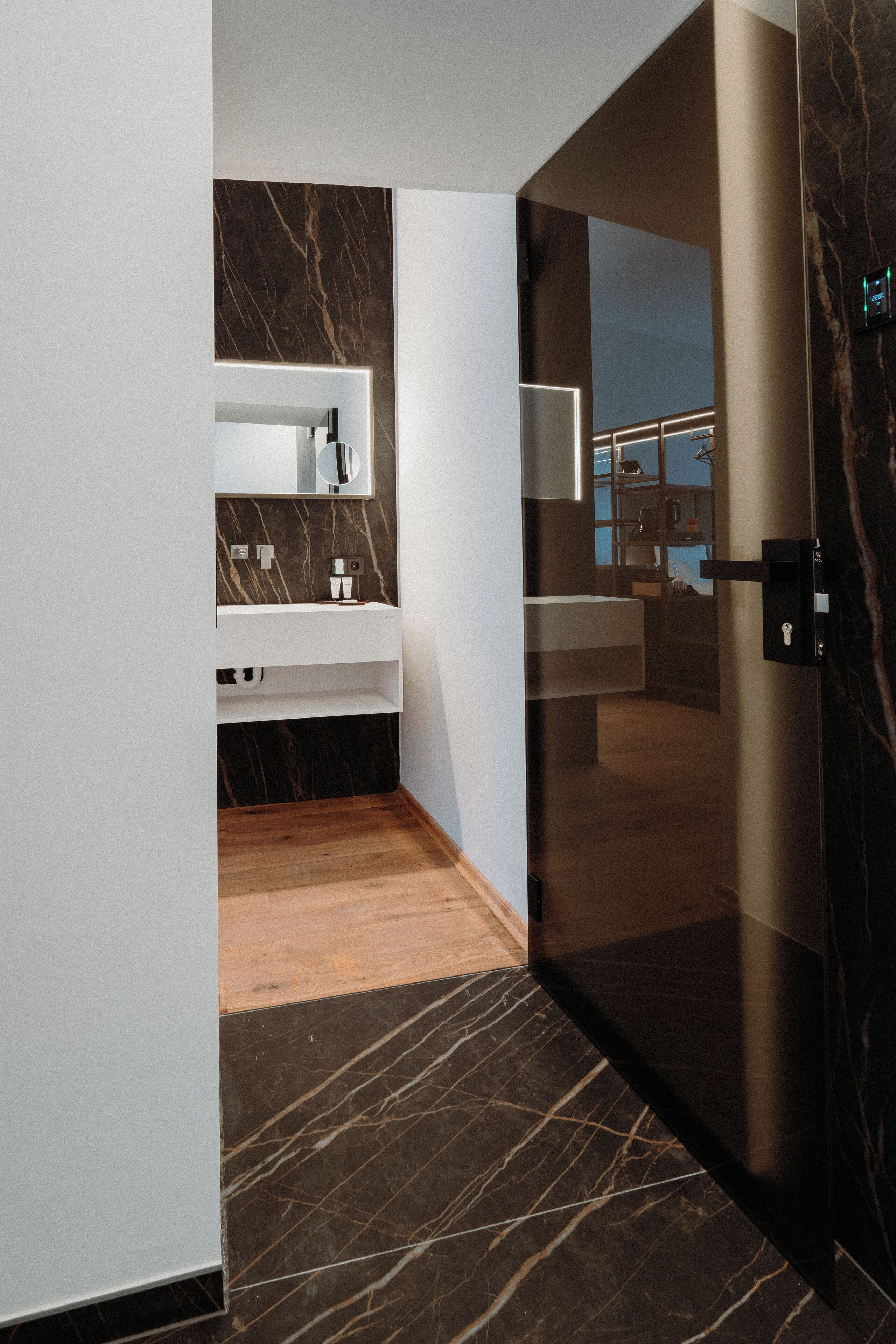 Une salle de bain moderne avec un meuble-lavabo en marbre, un lavabo séparé et une douche à parois de verre.