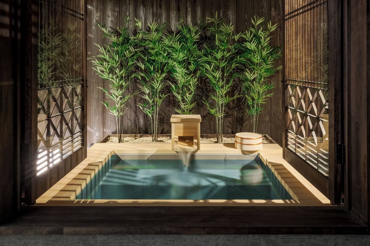 Ein Spa-Bereich aus Holz mit einem Pool, einer Holzbank und einem kleinen Hocker.