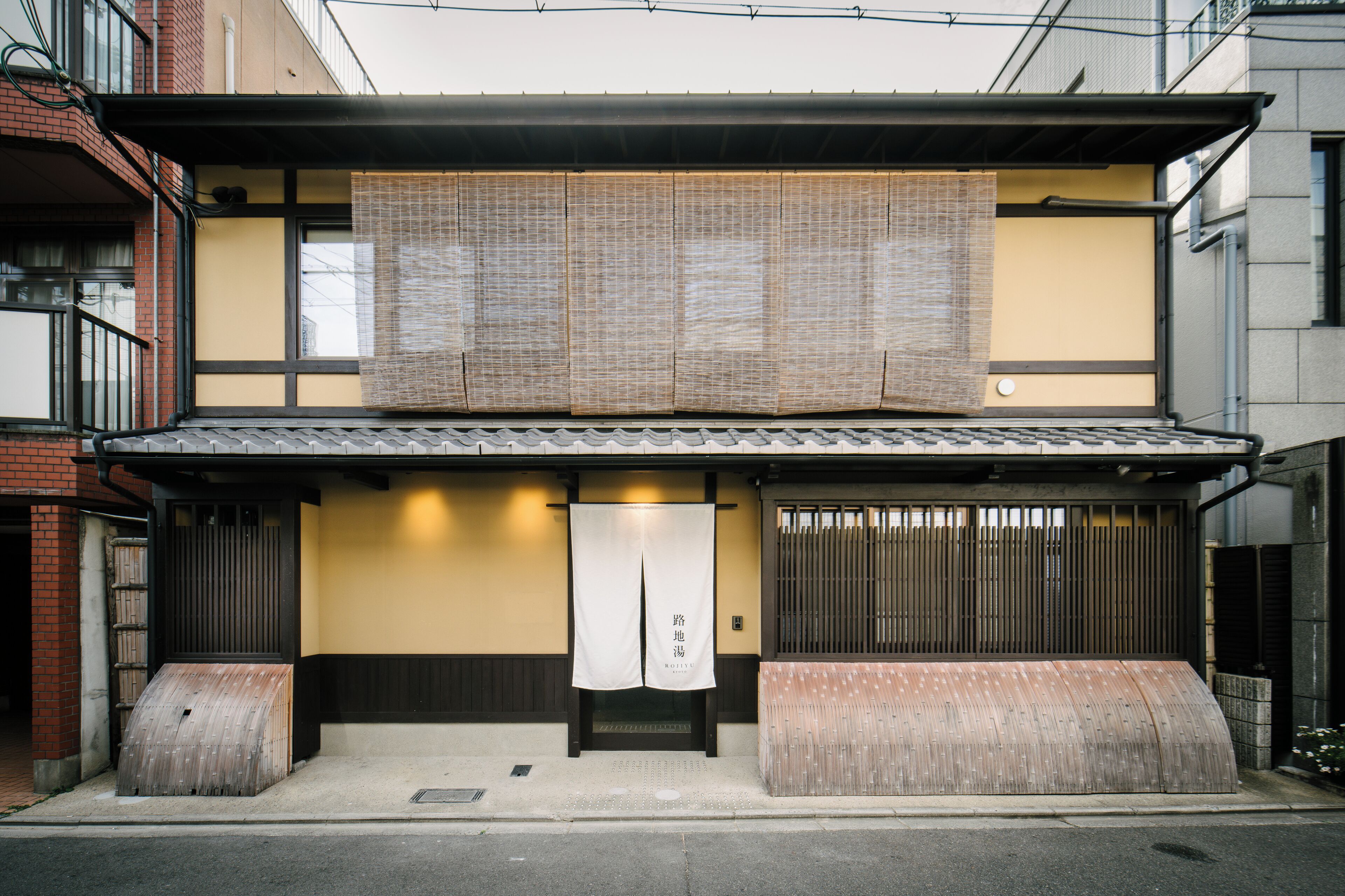 Un bâtiment japonais traditionnel, avec un toit recouvert de tuiles, des portes coulissantes en bois et une petite entrée.