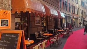 A caf é with outdoor seating, a red carpet, and a menu board. - Rapallo 2-bed Apt, Sleeps 5 With Hot Tub (Rapallo)