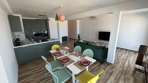 Un appartement moderne comprenant une cuisine, un coin repas et un salon.