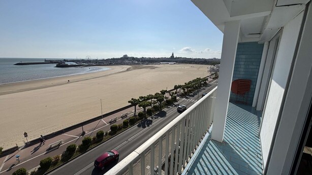Un balcon donnant sur une plage et une route.