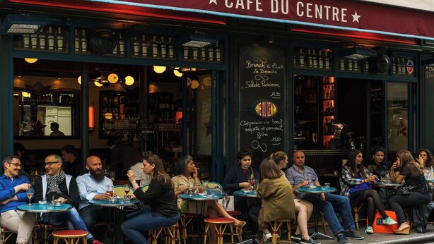 A cafe with outdoor seating and a chalkboard menu.