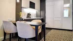 A modern kitchen with a dining area, featuring a black and white patterned rug, a table with chairs, and pendant lighting. - Fort by Baltic Home (Swinoujscie)