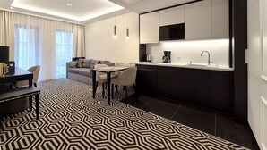 A modern hotel room with a dining area, kitchenette, and a patterned floor. - Fort by Baltic Home (Swinoujscie)