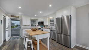 Una cocina moderna con armarios blancos, electrodomésticos de acero inoxidable y una isla de madera.