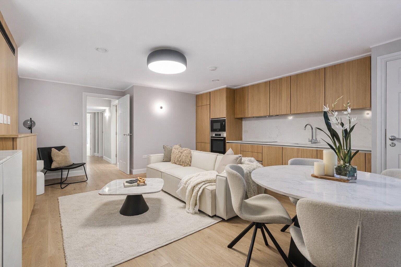 Un appartamento moderno con soggiorno, sala da pranzo, cucina e un corridoio.