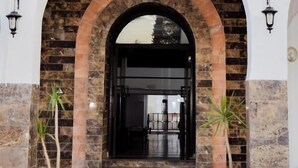 La entrada del Hotel Le Grand, con un arco de ladrillo y plantas en macetas.