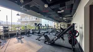Ein Fitnessstudio mit Laufbändern, Crosstrainern und Gewichten.