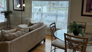 A living room with a sofa, chairs, a dining table, and a chandelier. - Amazing 1BR condo on the ground floor (Myrtle Beach)